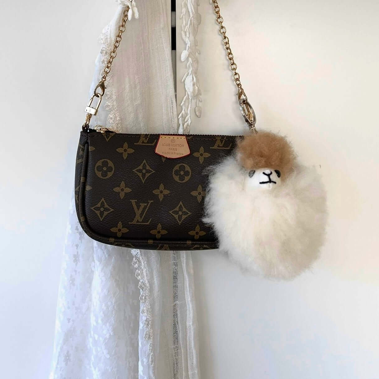 Brauner Anhänger aus Alpakafell im Alpaka-Design an einer stilvollen Louis Vuitton Tasche
