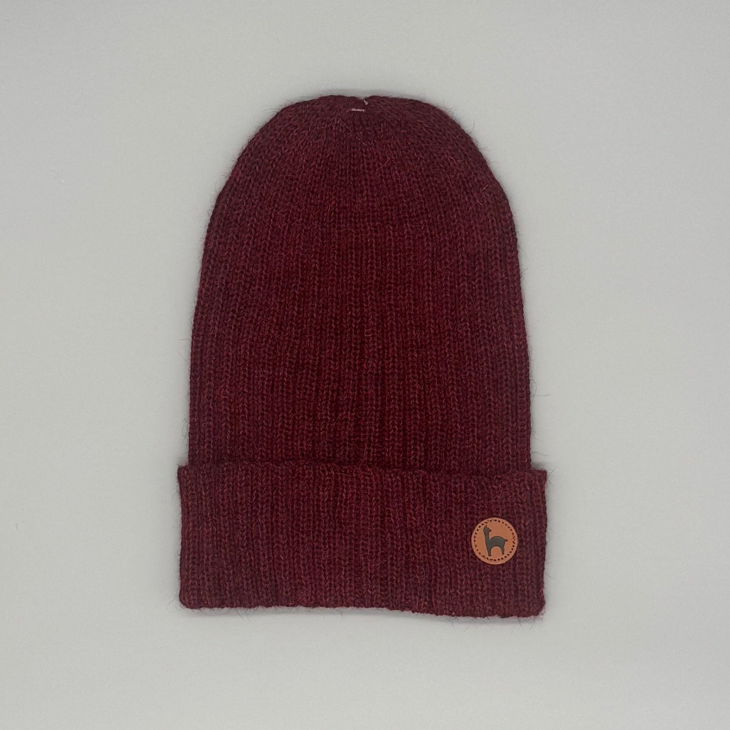 Weiche Beanie aus Baby-Alpakawolle in Rot mit Umschlag und Logo, ideal für Damen und Herren.