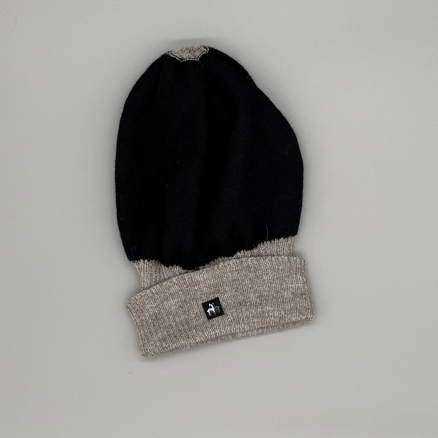 Alpaka Wendemütze in Schwarz und Beige aus 100% Baby-Alpakawolle, modern und weich, unisex, für empfindliche Haut.