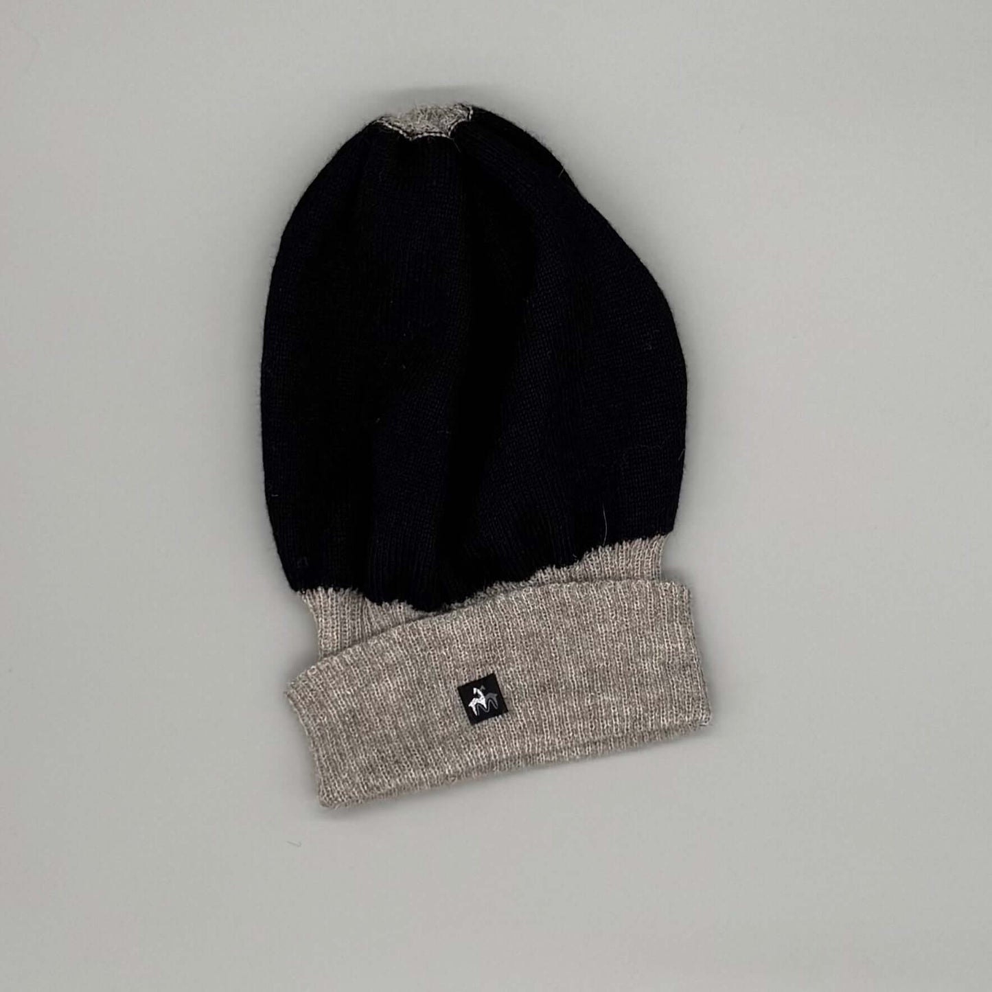 Alpaka Wendemütze in Schwarz und Beige aus 100% Baby-Alpakawolle, modern und weich, unisex, für empfindliche Haut.