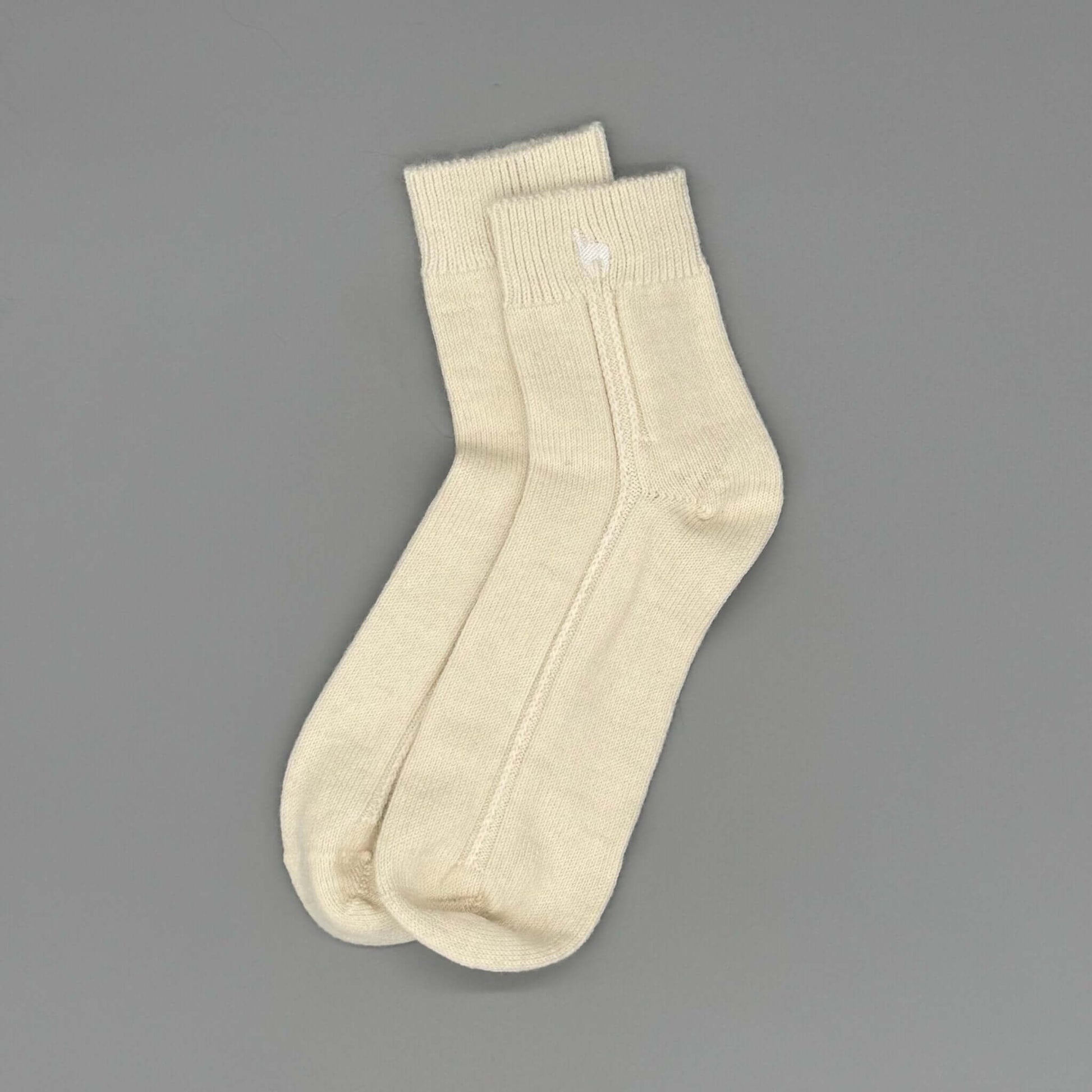 Warme Socken aus Alpakawolle in Cremefarbe, ideal für Komfort und natürliche Materialien.