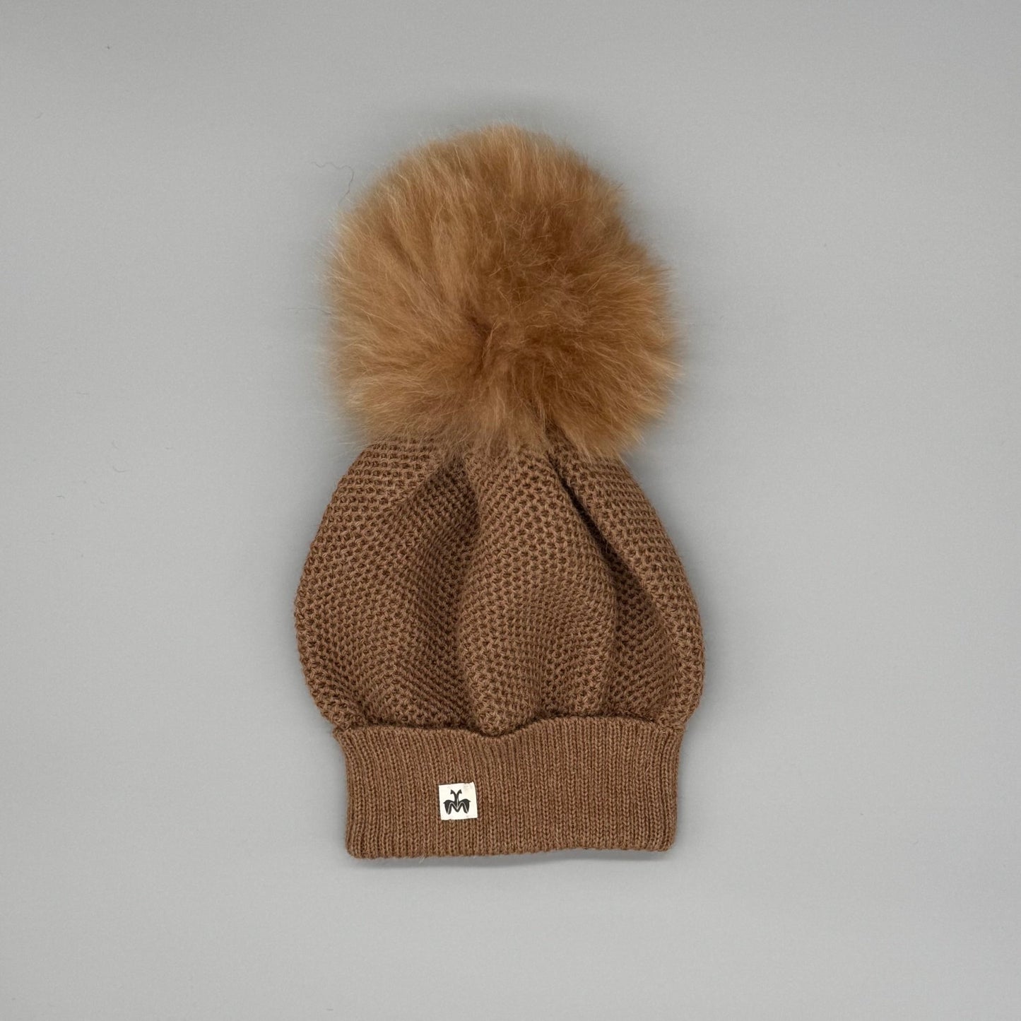 Alpakamütze Damen aus 100 % Babyalpaka in Braun mit Fellbommel, handgefertigt für warme Wintertage.