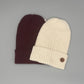 Besonders weiche Beanie aus Baby-Alpakawolle in Creme und Rot, ideal für Damen und Herren, vielseitig tragbar.