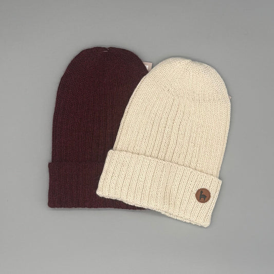Besonders weiche Beanie aus Baby-Alpakawolle in Creme und Rot, ideal für Damen und Herren, vielseitig tragbar.