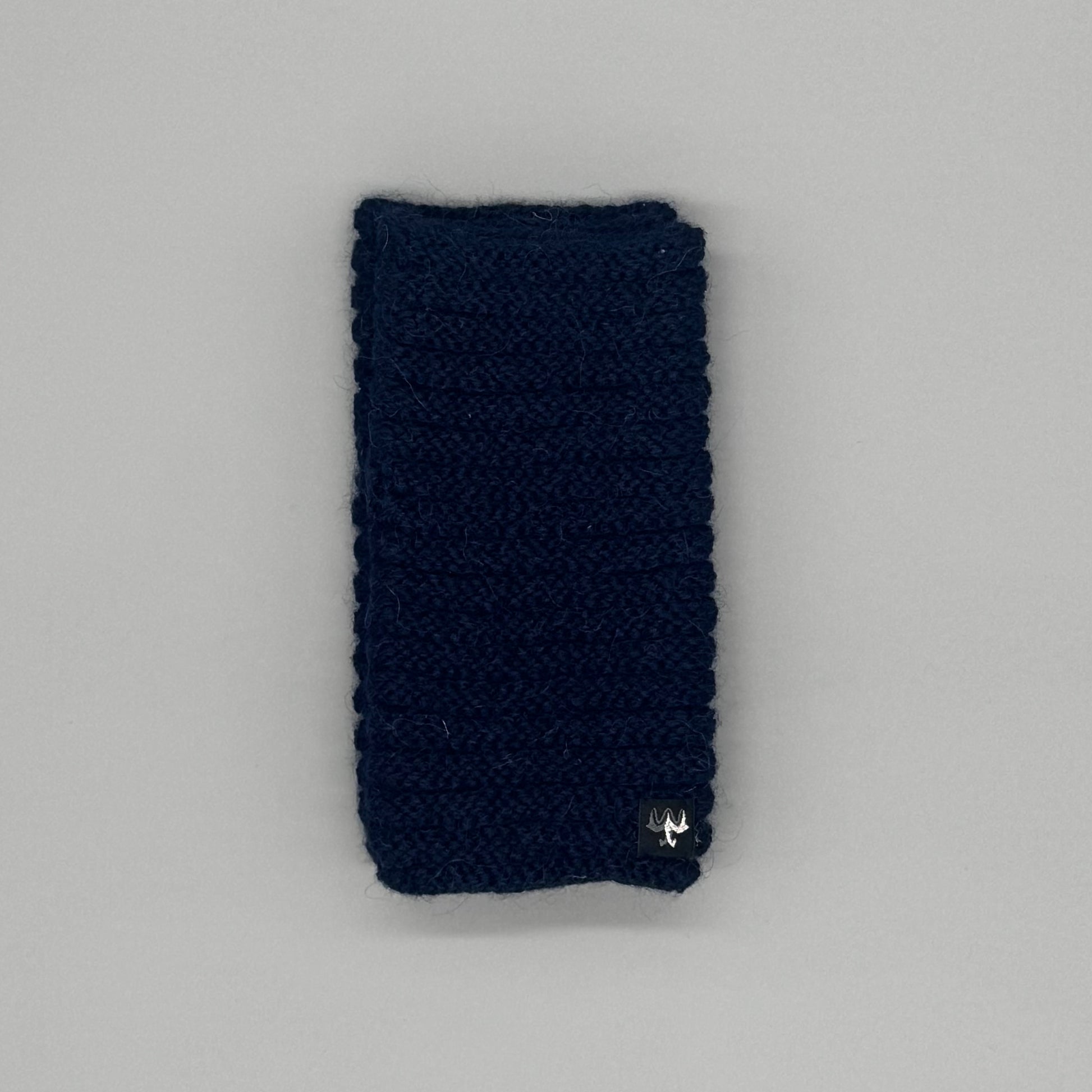 Alpaka Pulswärmer aus Baby-Alpakawolle im Röllchenmuster in Navy auf grauem Hintergrund.