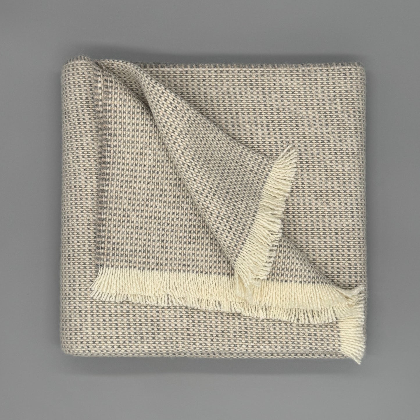 Sofadecke Baby Alpaka Wolle aus 70 % Baby Alpaka und 30 % Wolle, modernes Design mit Fransen in Beige und Grau.