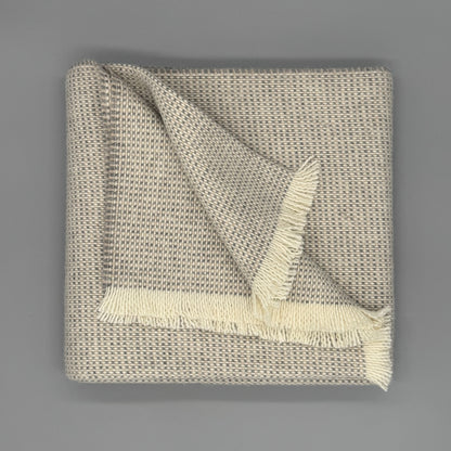Sofadecke Baby Alpaka Wolle aus 70 % Baby Alpaka und 30 % Wolle, modernes Design mit Fransen in Beige und Grau.